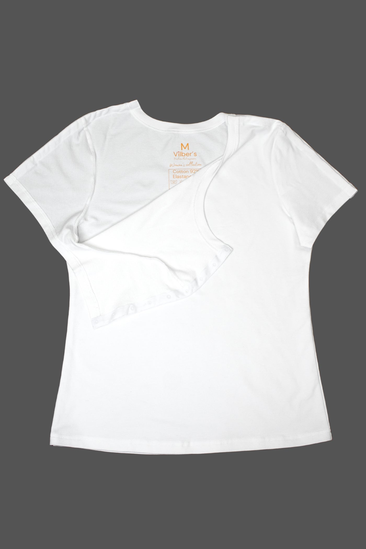 Ein weißes, adaptives T-Shirt von Vilber's, flach ausgelegt, das die offene Schulterpartie und das innen gedruckte Etikett zeigt. Hochwertige Rollstuhlkleidung für Damen.