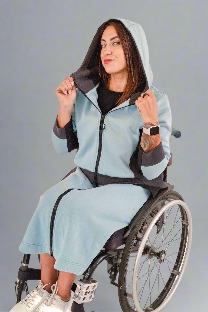 A woman in wheelchair weaaring Vilber's adaptive hoodie and skirt in color Sage