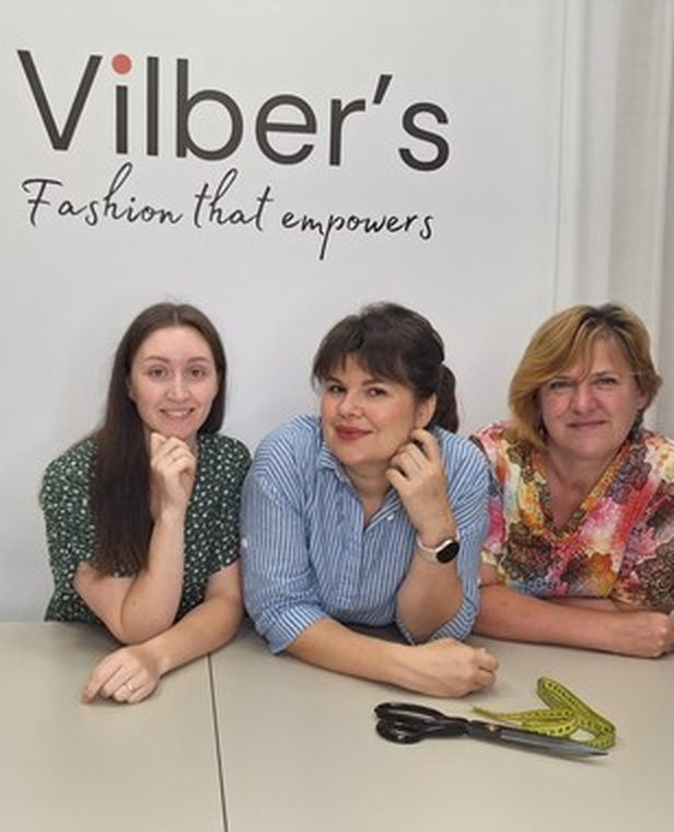 Three of the Vilber's team at the brand wall