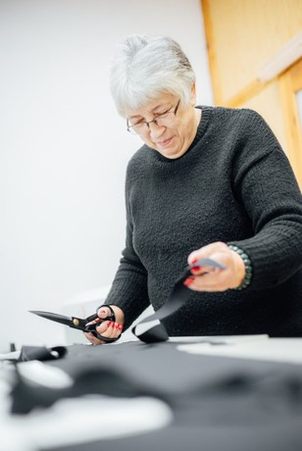 A seamstress cutting fabric in the Vilber's workshop