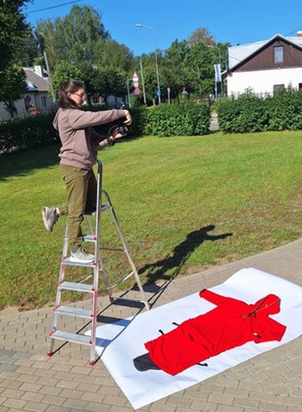 A red rain coat laid out during a photoshoot