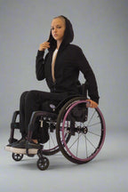 Girl in a wheelchair dressed in Vilber's woman's jersey wheelchair adaptive pants and black jacket