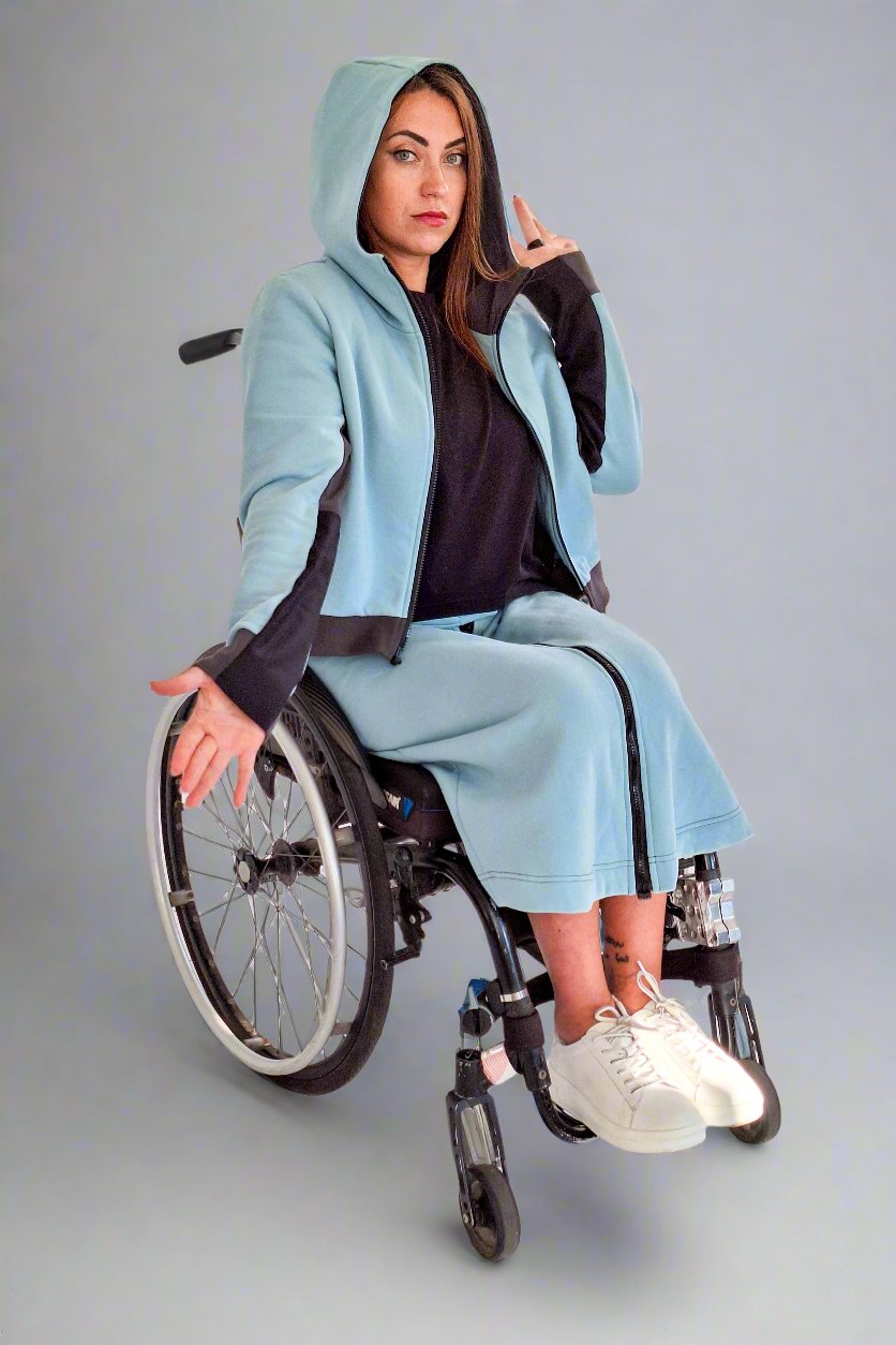 Woman in a wheelchair wearing Vilber's adaptive tracksuit sage, showing dirt resistant sleeves